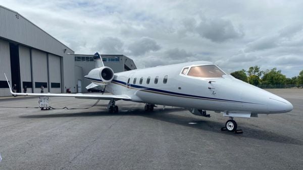 A Bombardier Learjet 60 parked in front of a hangar