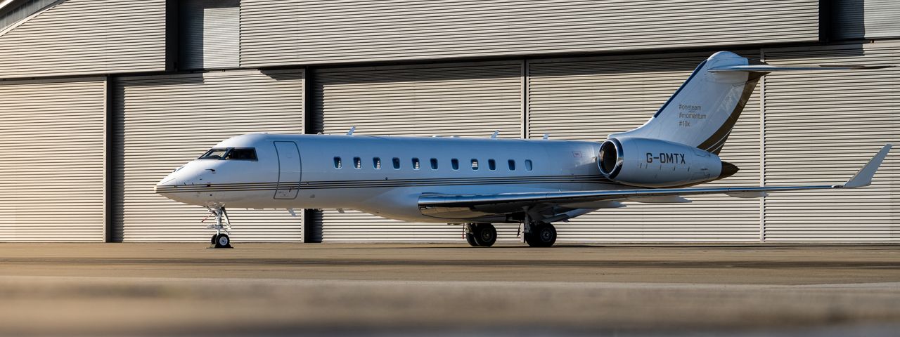 A Bombardier Global 5000 parked in front of a hangar
