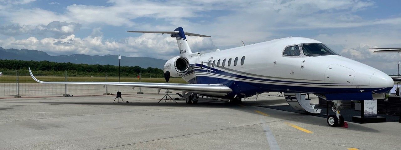 A Cessna Citation Longitude parked on a runway with its stairs down.