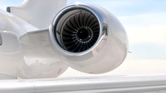 A close-up of a plane wing and an engine attached to the side of an aircraft.