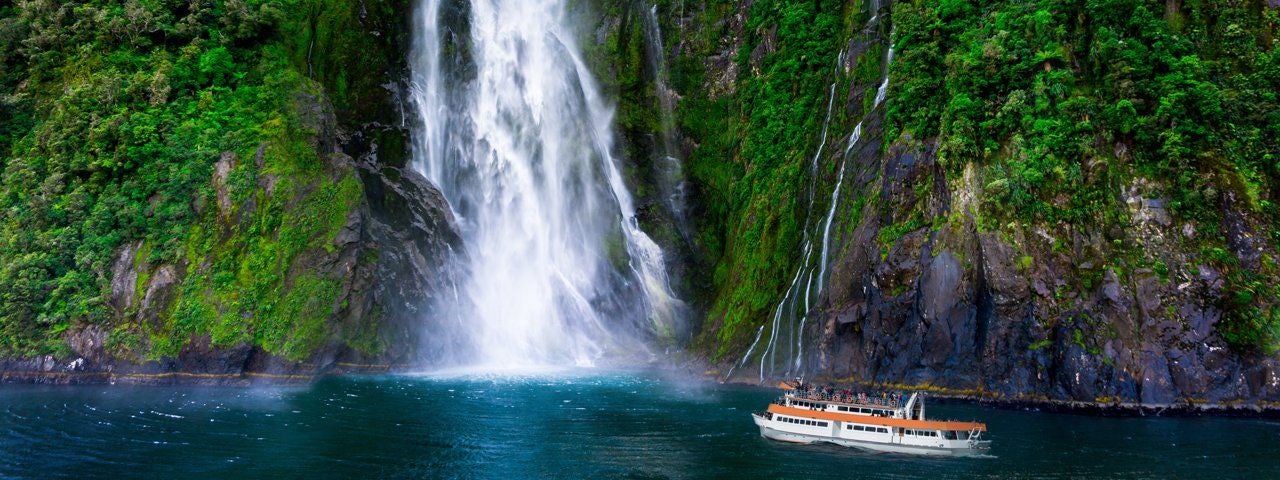 A ferry near Stirling Falls at Milford Sound, New Zealand.