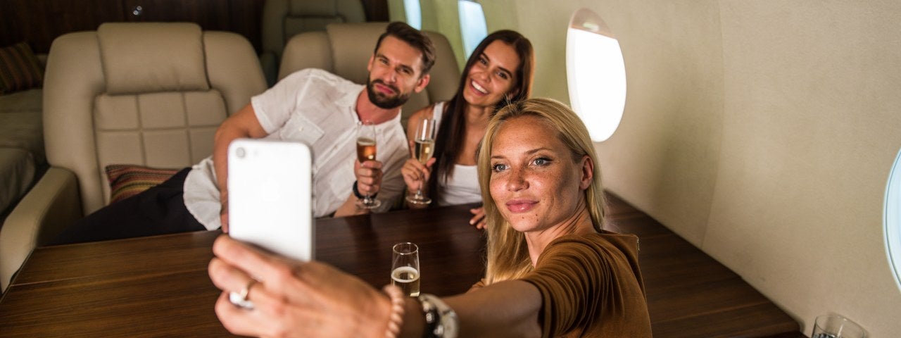 A group of friends taking a selfie in a private jet.