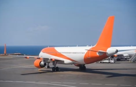 A passenger aircraft parked on a runway at an airport next to another passenger jet.