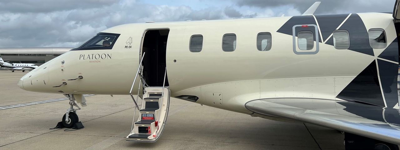  A Pilatus PC24 parked and waiting for passengers to board with the door open and stairs down. 