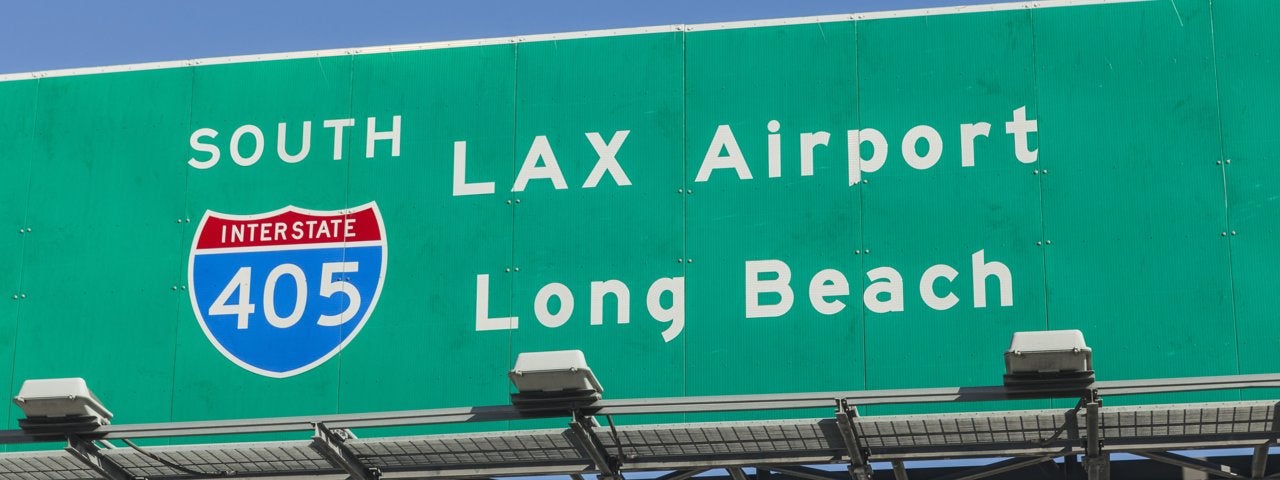 A road sign for LAX Airport and Long Beach.