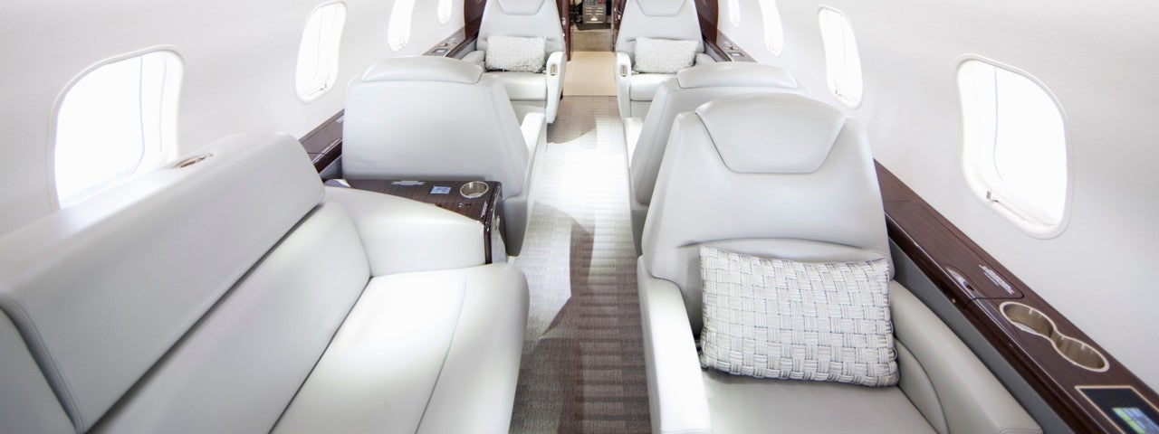 A spacious white cabin area of a private charter jet. 