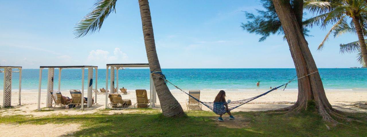  a woman sitting in a hammock on the Nirwa Beach, Bintan Island in Indonesia
