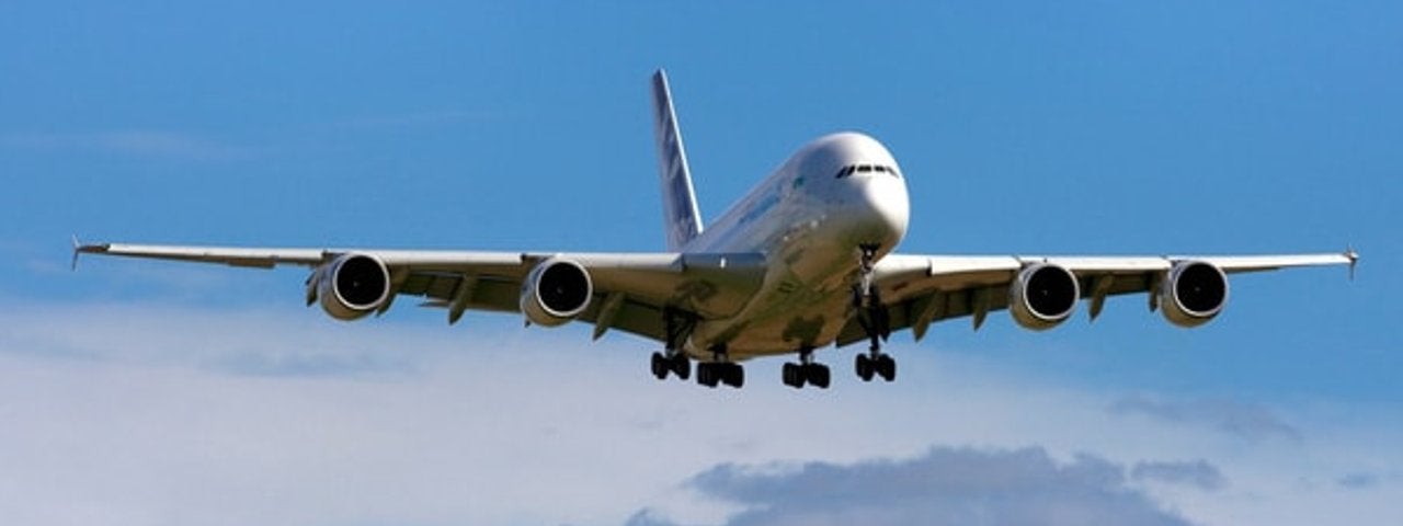 An Airbus A380 with its landing gear out as it descends.