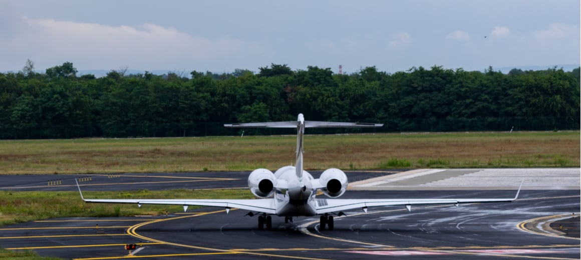 A rear view of a private jet on the tarmac getting ready to take off.