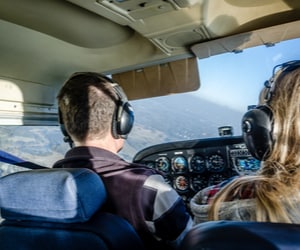 A man and woman flying a small airplane.