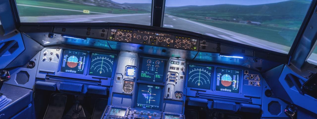 Inside a flight simulator with a view of a runway.