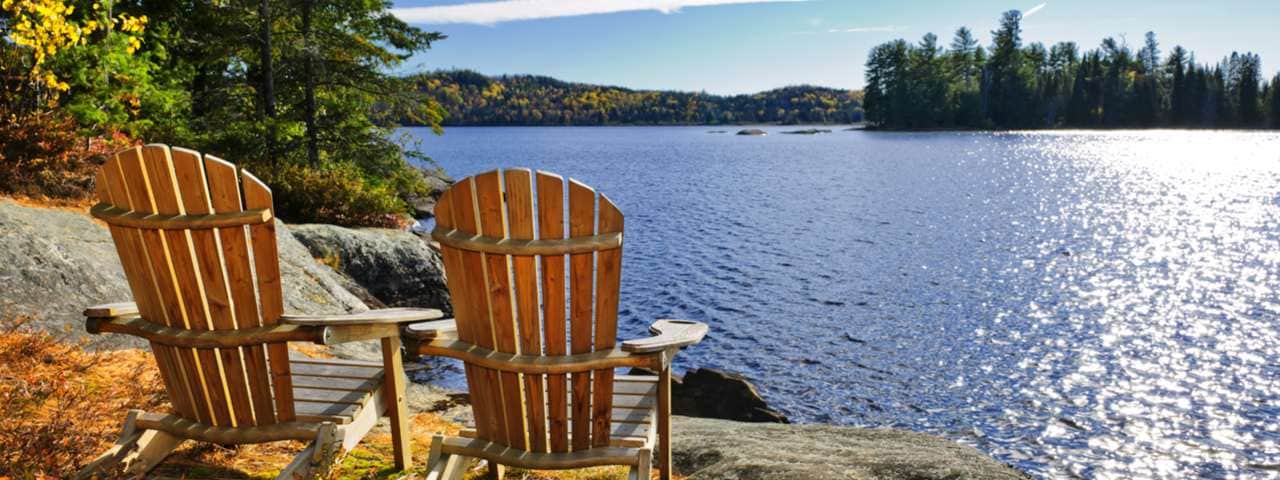 View of two chairs by the shore of a lake in Ontario Canada.
