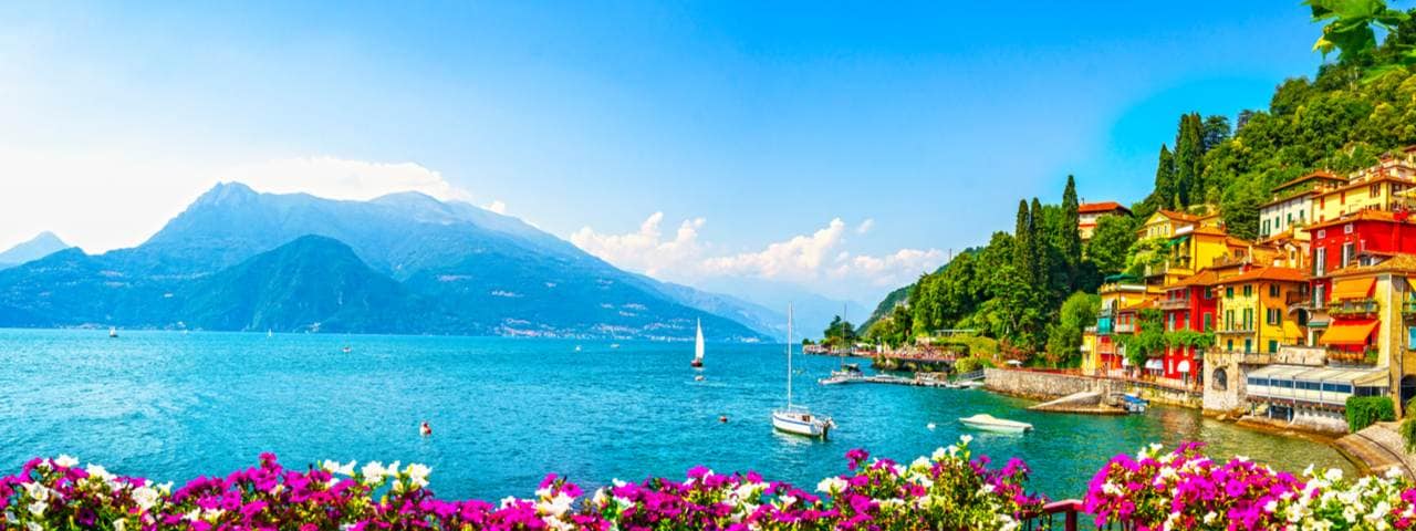View of Lake Como on a sunny day with mountains in the background.