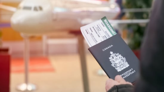 A passenger hold the passport with flight ticket inside of it