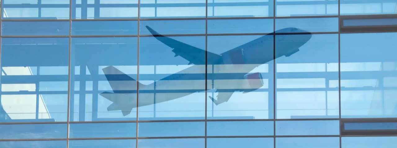 The reflection of the airplane take off in the departure building window