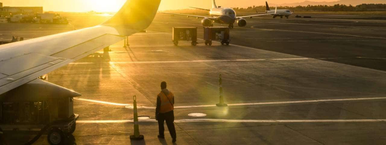 The mechanic standing on the runway in the evening light