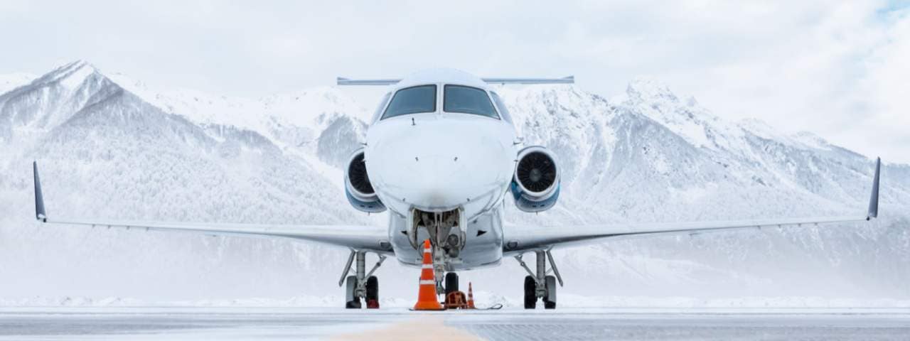 Private jet on runway near snowy mountains