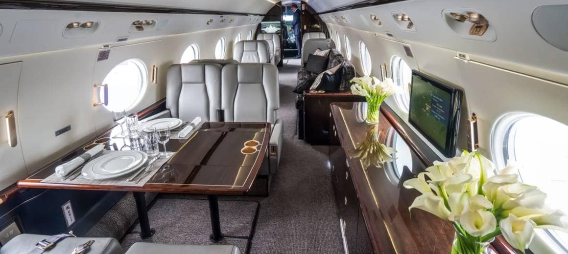 Luxury private business jet interior with wooden tables
