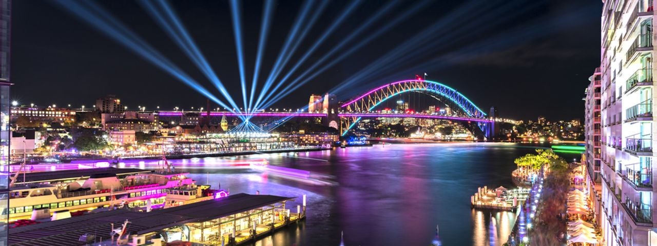Circular Quay and Sydney Harbour Bridge illuminated with colourful lights, Sydney.