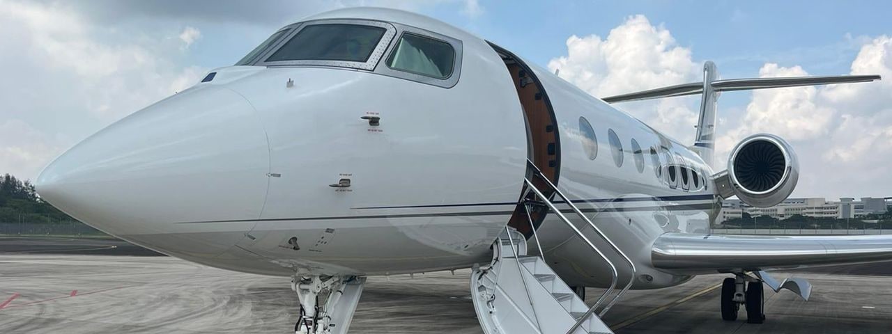 Closeup of a private jet with its door open on the runway 