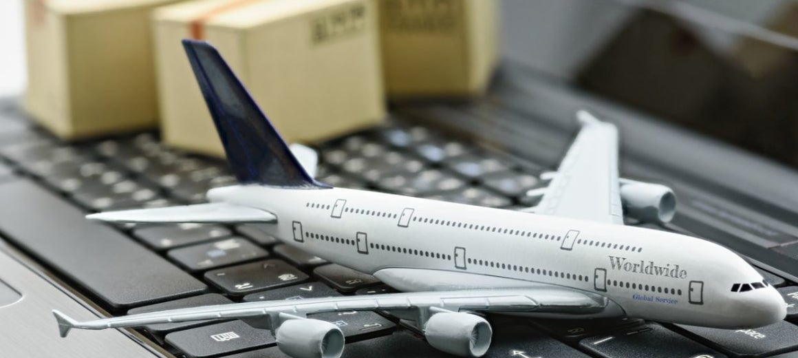 Model airplane on keyboard with freight boxes in background