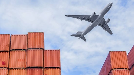 Cargo plane flying over shipping containers 