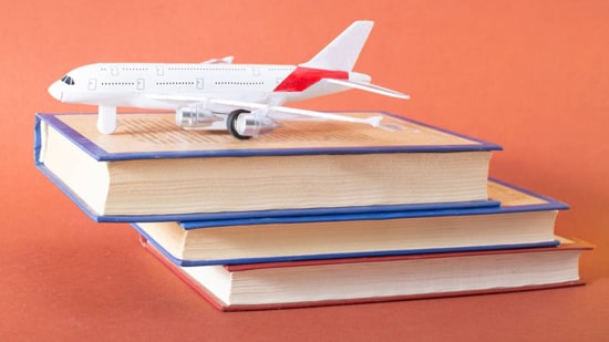 White model airplane on three books.