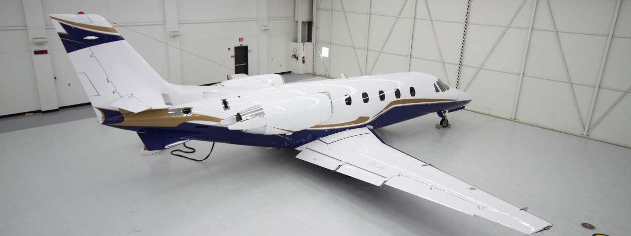 Brand new blue and white private jet in a brand new hangar.