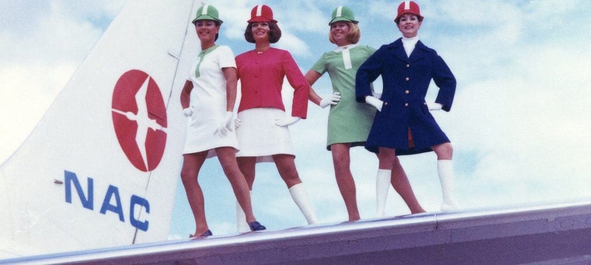 A group of air hostesses posing in their 1970s ‘lollipop’ cabin uniforms on the wing of an NAC plane.