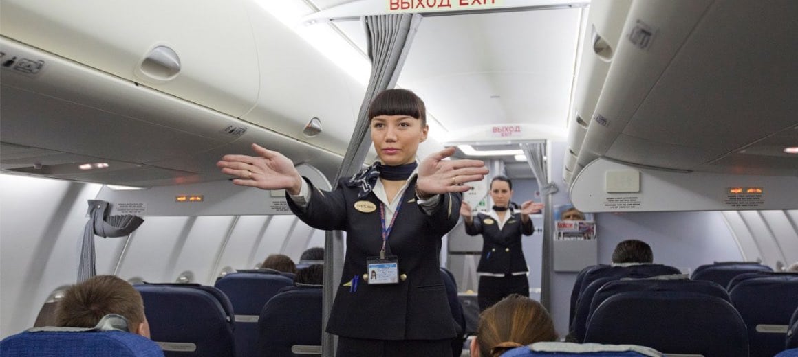Flight attendants performing a pre-flight safety demonstration.