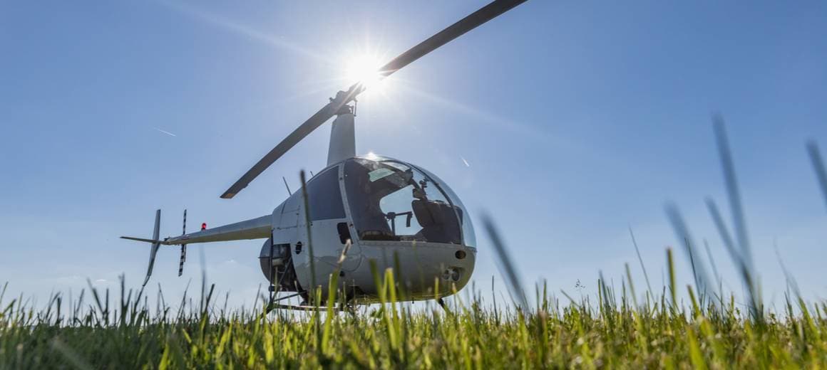 Robinson R22 helicopter parked on a grass.