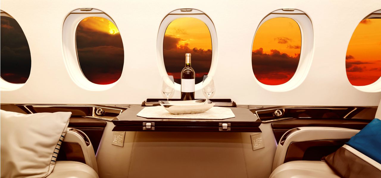 Intérieur d'un jet de luxe avec un coucher du soleil orange et rouge hors de la fenêtre