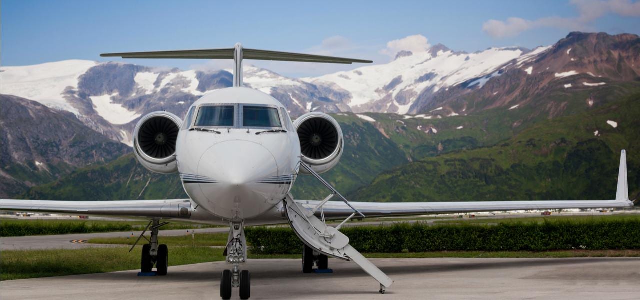 Jet privé de luxe prêt pour l'embarquement avec des montagnes de crête de neige à l'arrière-plan
