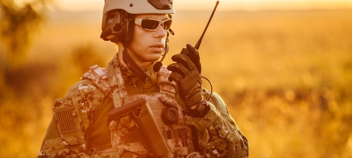 Portrait of young NATO soldier holding a radio station
