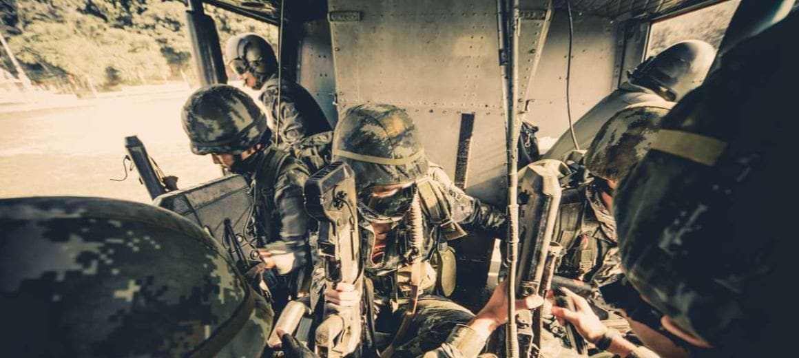 Soldiers boarding a military helicopter in battle gear