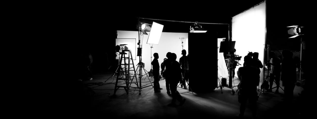 Schwarz-weißes Silhouettenbild hinter den Kulissen einer Filmproduktion.