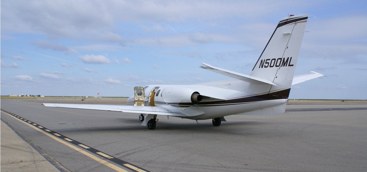 A Cessna Citation on the runway on a cloudy day