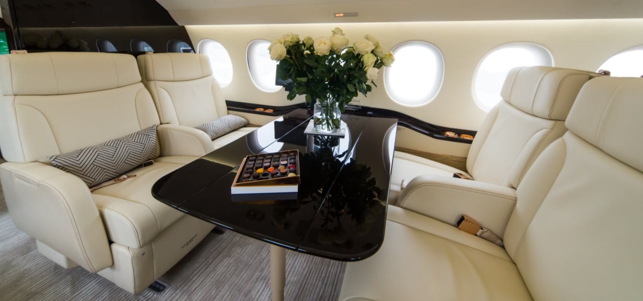 White leather interior of luxury jet with roses on table