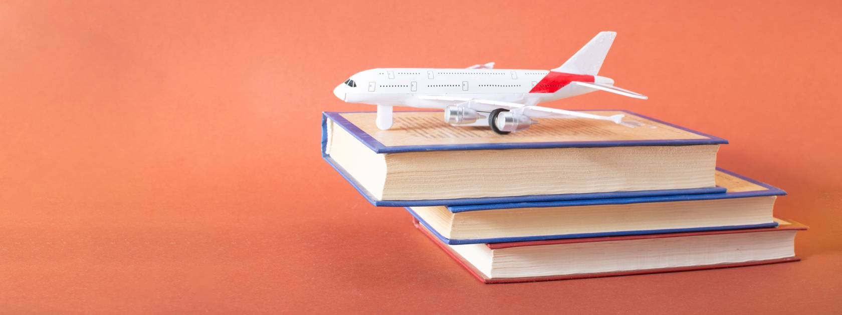 White model airplane on three books