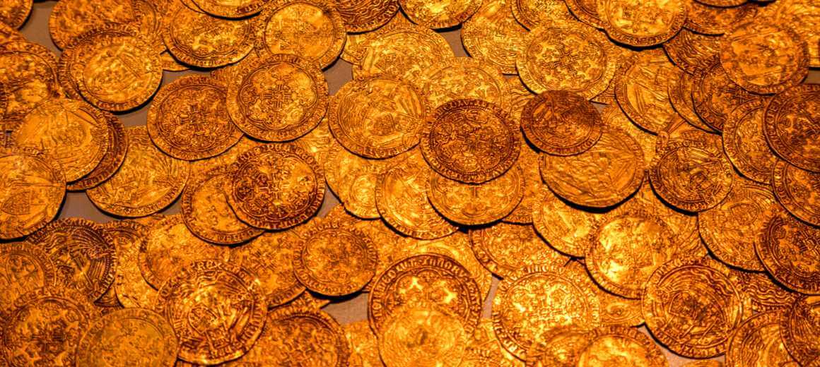  Loosely scattered ancient gold coins on a table.