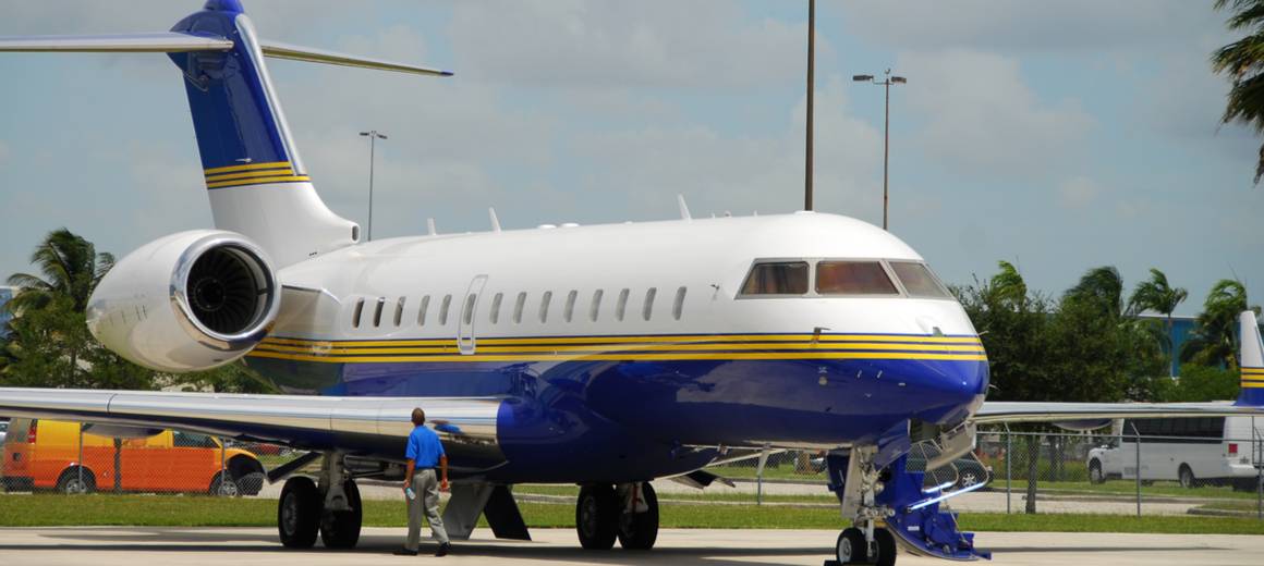 White blue and yellow Bombardier Global 5000 luxury jet on runway