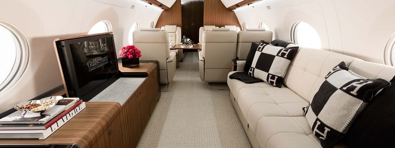 The entertainment area of a Gulfstream G650ER with a TV and couch.