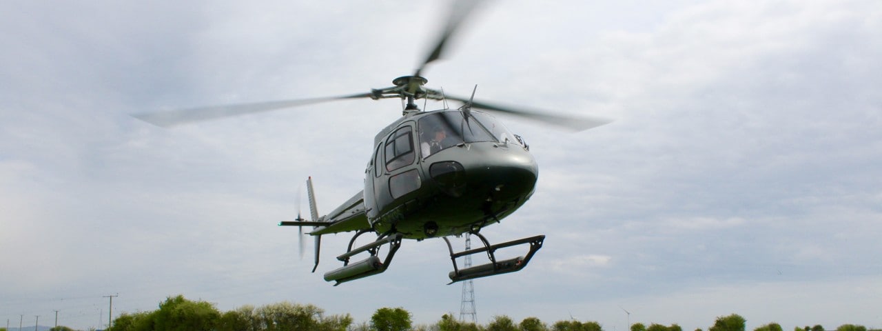 The Eurocopter AS355 Écureuil 2, now Airbus Helicopters AS355 Écureuil 2, coming into land with a ladder extended.