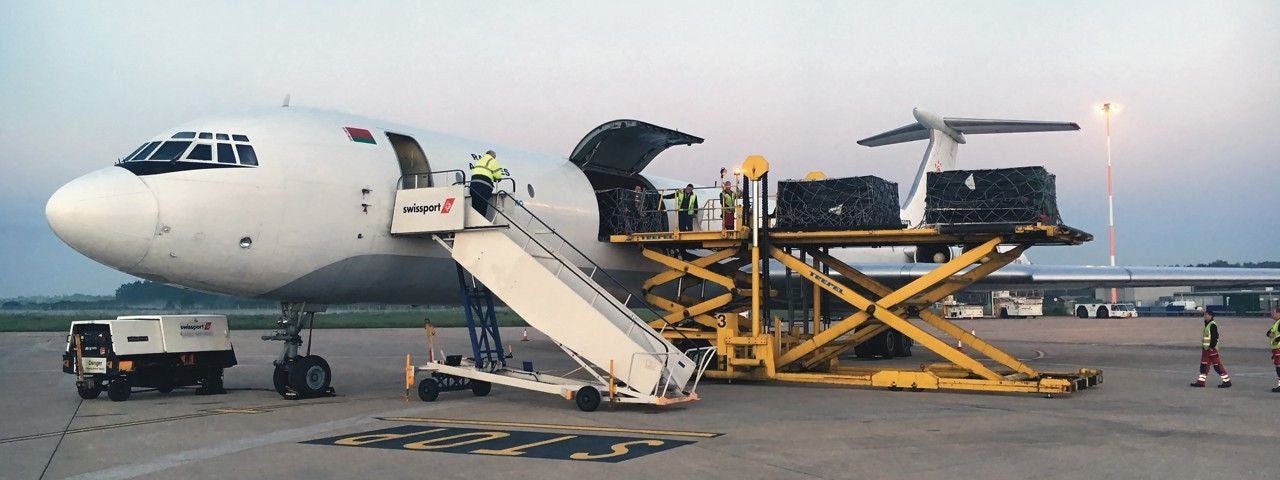 The Ilyushin IL-62 parked on a runway with cargo being loaded.