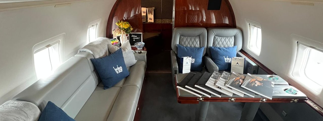 The interior of a Challenger 601. Various items, such as the cushions, gift bags, and magazines, have been specifically prepared for a customer.