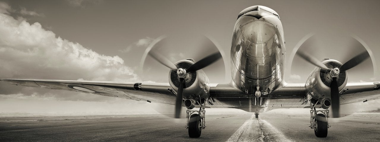 A black and white image of a vintage airliner preparing for takeoff.