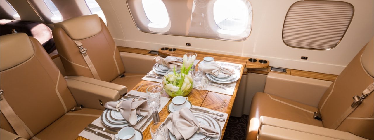 A table set out in the luxury interior of a private plane.