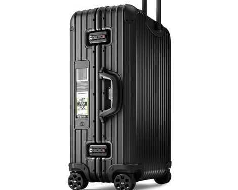 Black Rimowa suitcase with digital boarding pass display.
