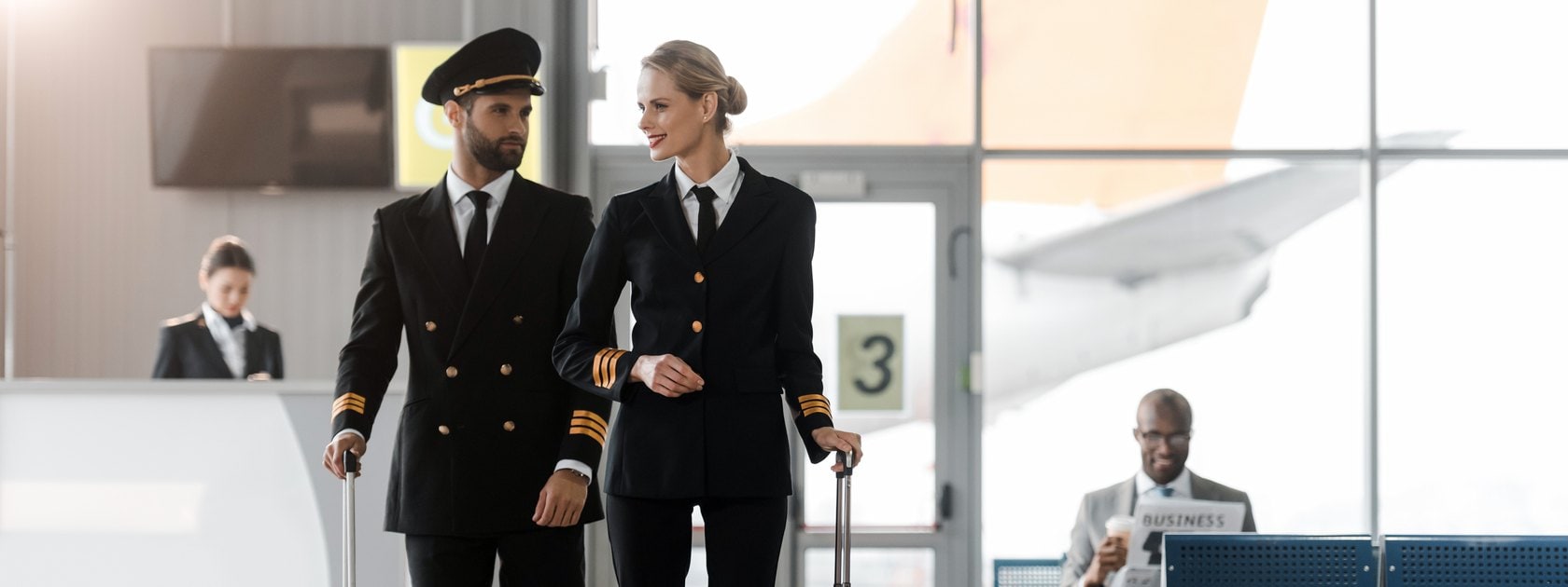 A male and female pilot walking through an airport.