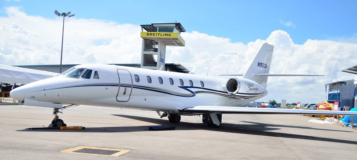 A long shot of a white Cessna Citation Sovereign on a runway